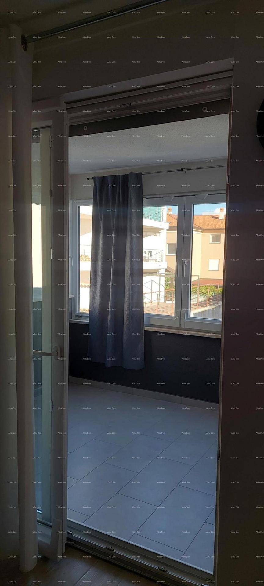 Blick auf den gefliesten Balkon mit umliegenden Gebäuden und viel Tageslicht.