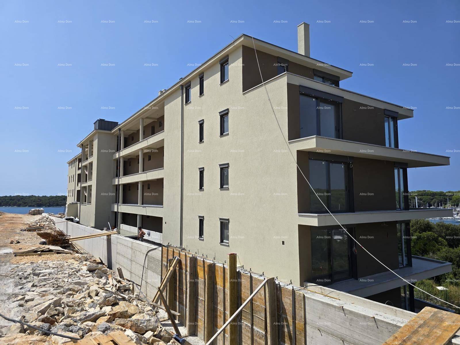 Modernes Wohngebäude im Bau mit heller Fassade und weitem Blick auf das Meer.