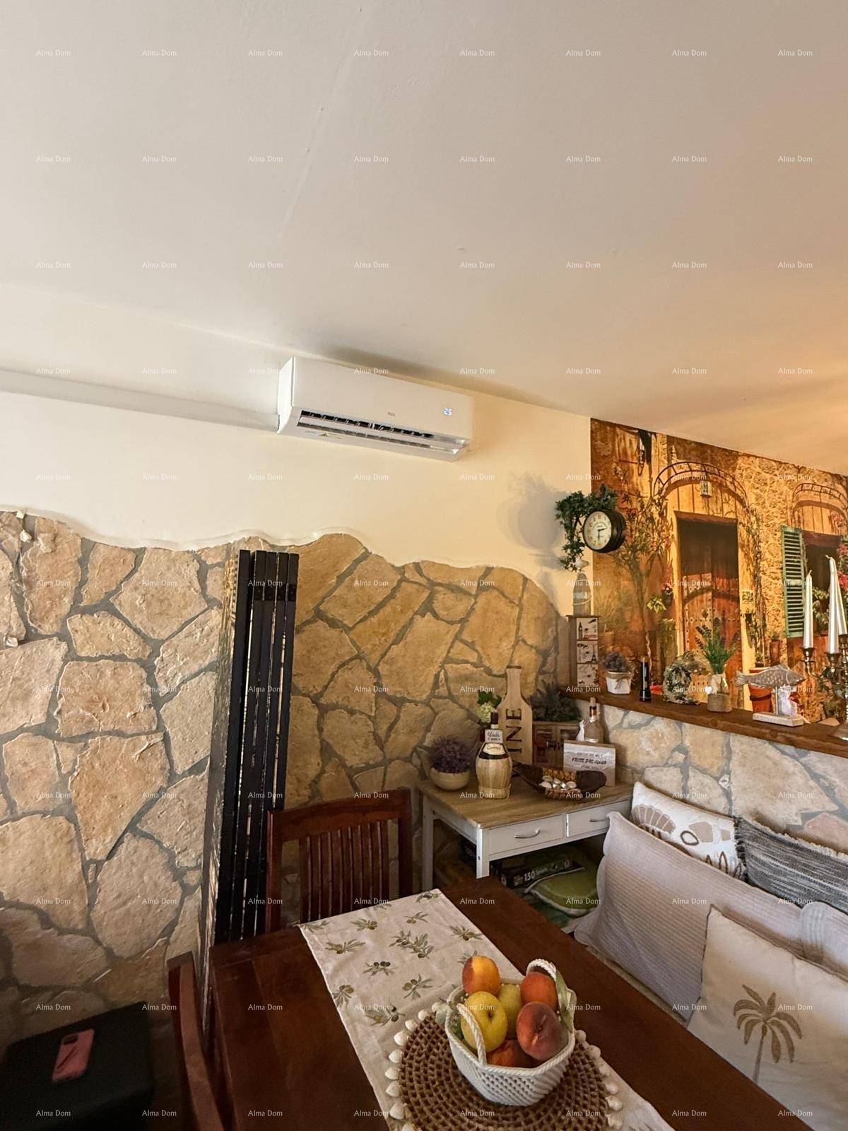 Heller Essbereich mit Holztisch, Steinwand-Dekor und installierter Klimaanlage für angenehmes Raumklima.
