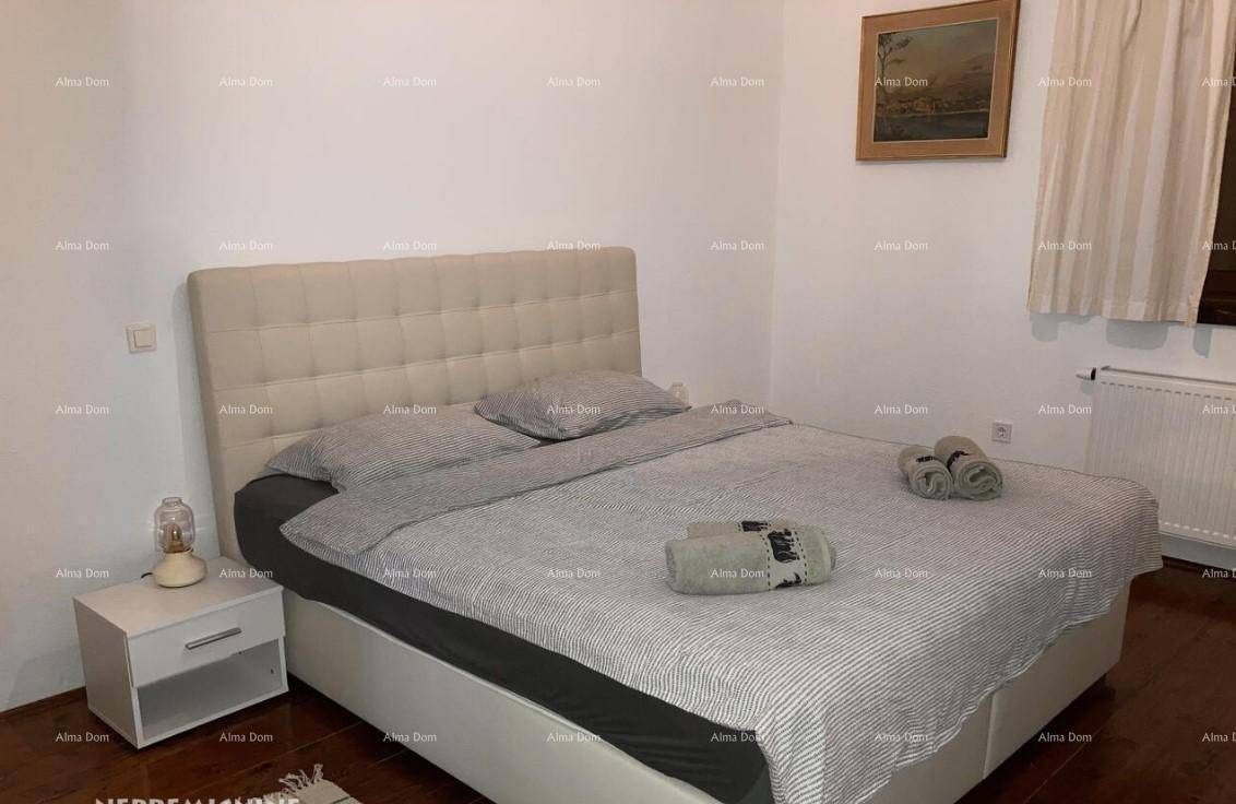 Schlafzimmer mit bequemem Doppelbett, grauer Bettwäsche und einem schlichten Nachttisch.