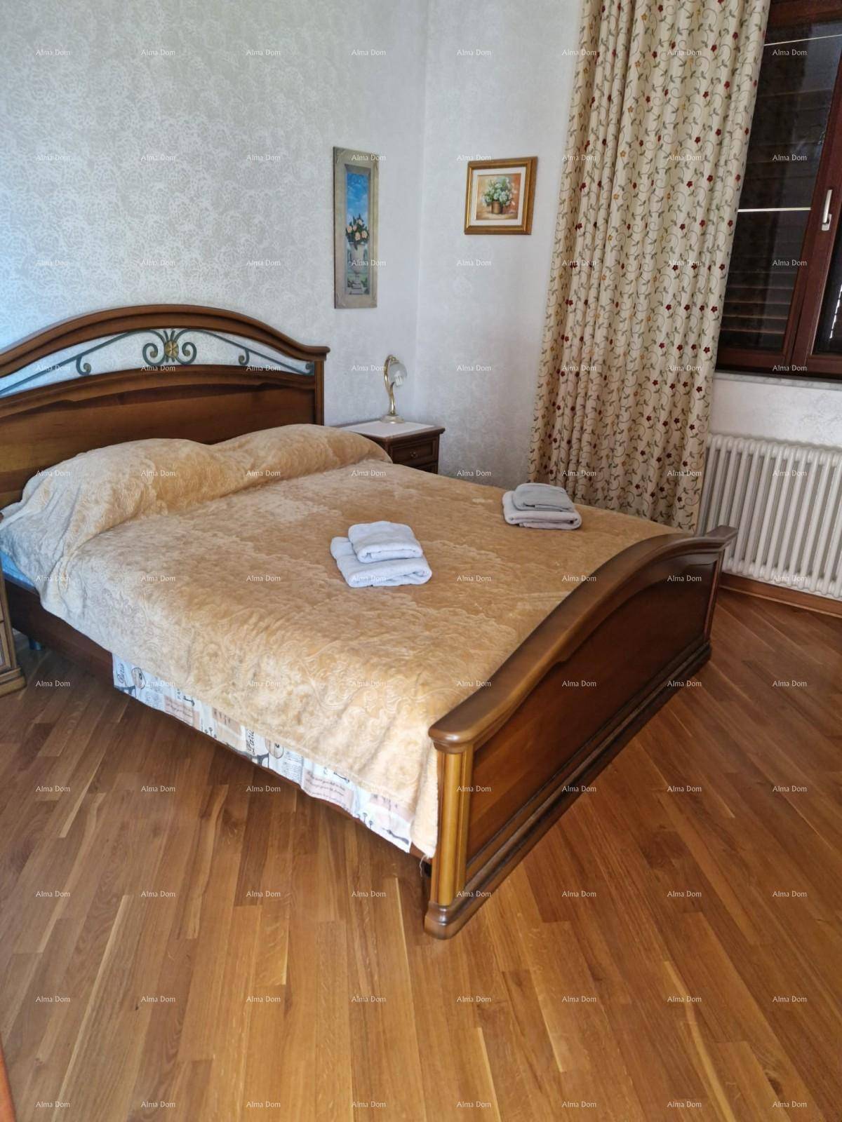 Helles Schlafzimmer mit Doppelbett, Holzboden und Heizkörper unter dem Fenster.