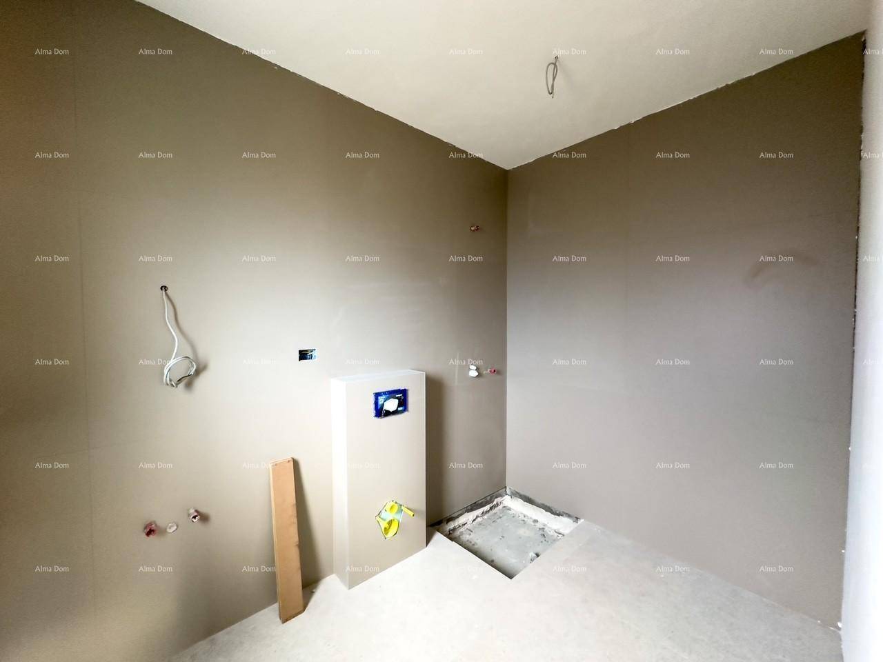 Unfertiges Badezimmer oder Technikraum mit vorbereiteten Anschlüssen und grauen Wänden im Rohbauzustand.