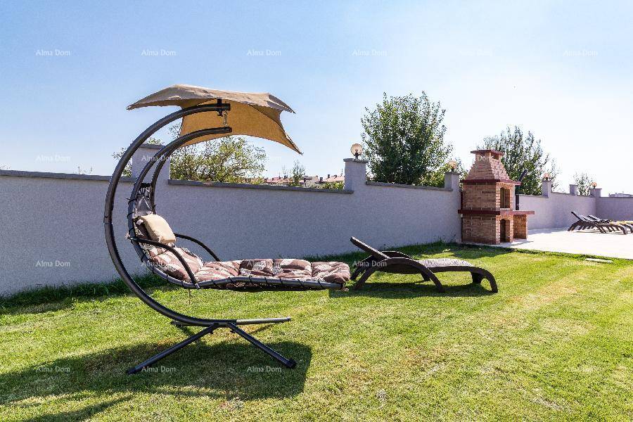 Grüner Gartenbereich mit moderner Sonnenliege und gemauertem Grillplatz für entspannte Stunden im Freien.