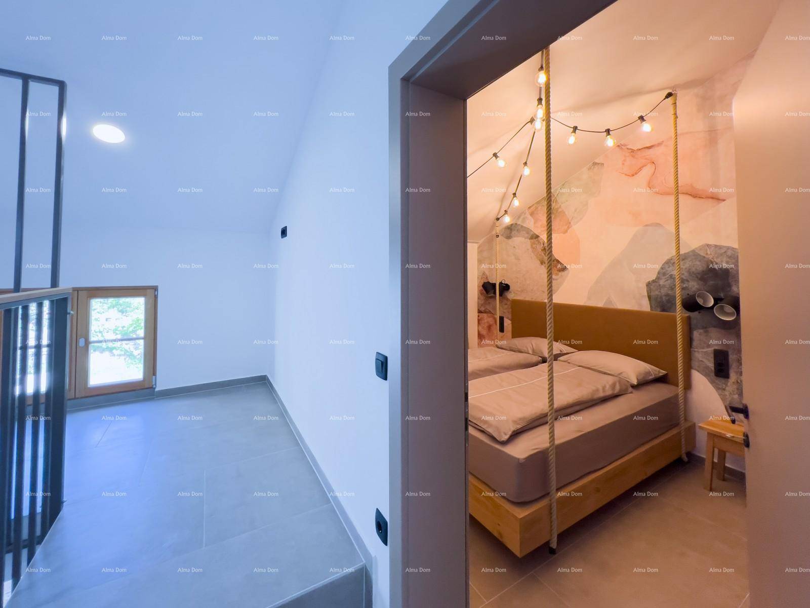 Heller Flur mit Treppengeländer und Blick in ein Schlafzimmer mit farbiger Wandgestaltung.