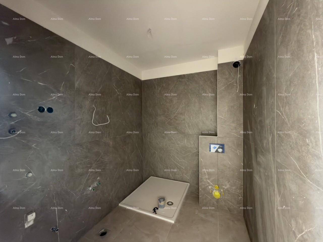 Modernes Badezimmer im Rohbau mit großformatigen Fliesen und vorbereiteter Duschwanne.