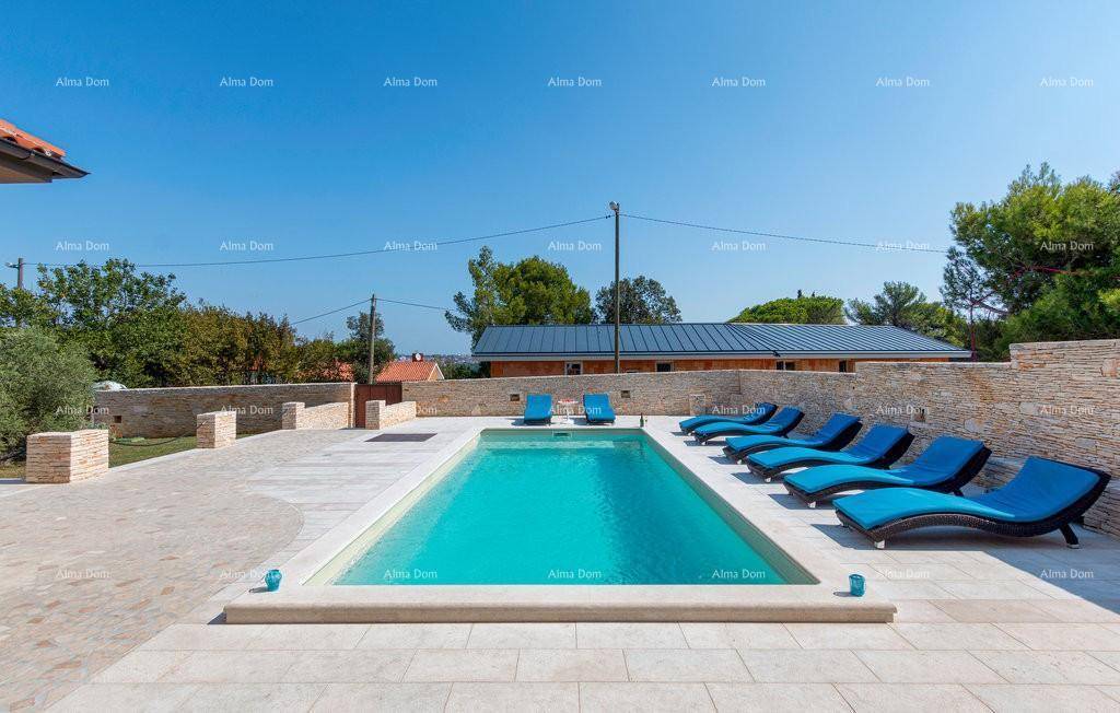 Erfrischender Pool mit zahlreichen Sonnenliegen auf der umliegenden Terrasse unter blauem Himmel.