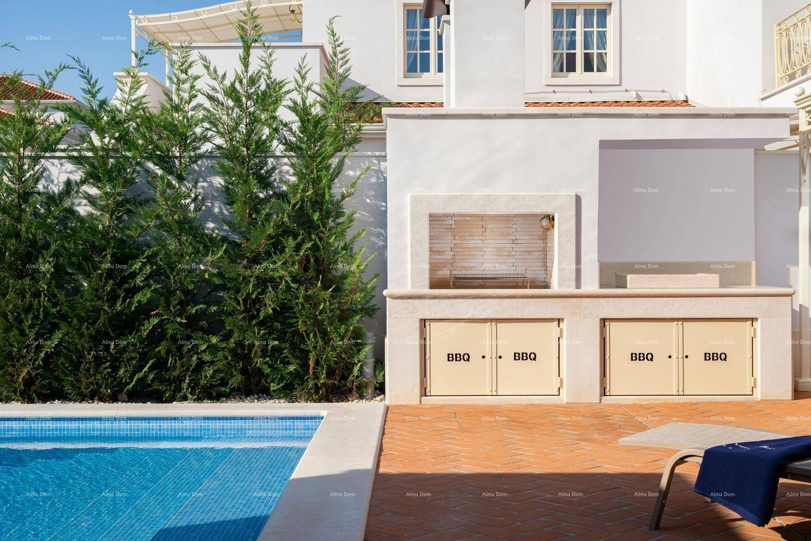 Integrierte Grillstation am Poolbereich mit Hecke und Sonnenliege.