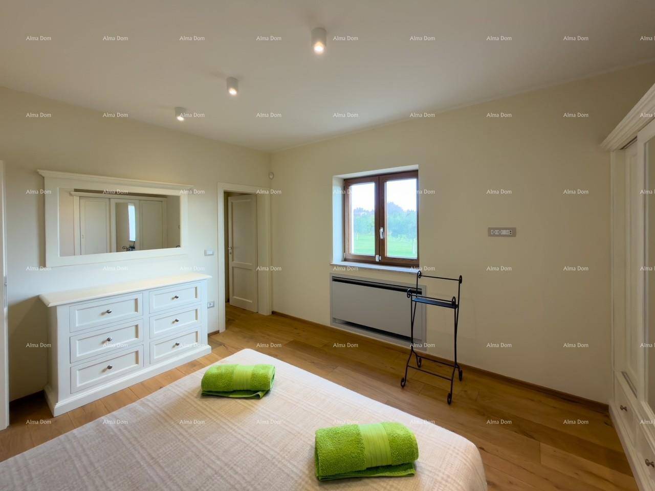 Geräumiges Schlafzimmer mit Holzboden, Kommode mit Spiegel und Fenster mit schöner Aussicht.