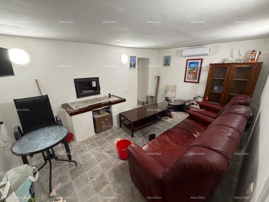 Wohnzimmer mit rotem Ledersofa, Kamin, Klimaanlage und verschiedenen Möbelstücken.