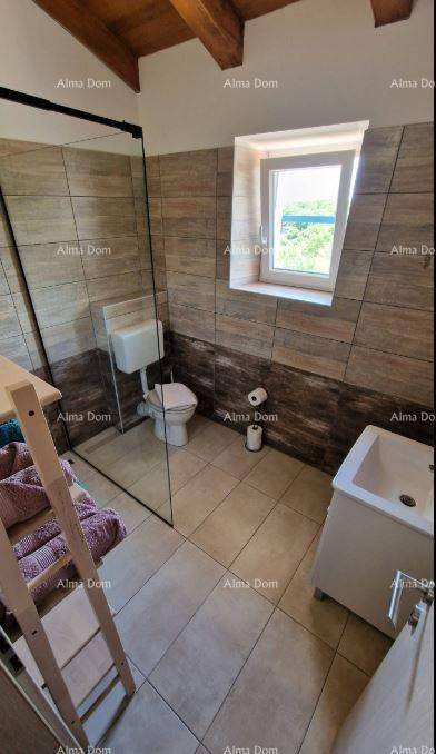 Modernes Badezimmer mit Fliesen, Duschbereich, Toilette, Waschbecken und Fenster.