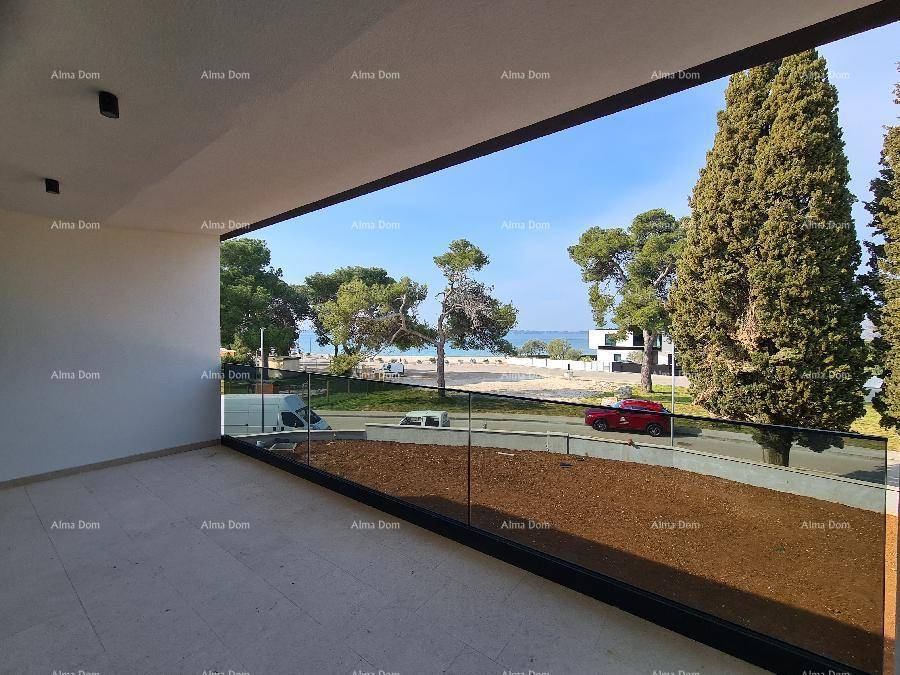 Geräumiger Balkon mit Glasgeländer und weitem Blick auf das Meer und die Küste.