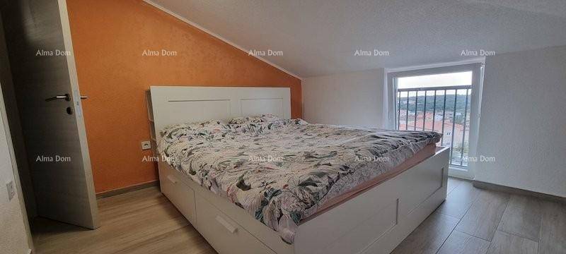 Helles Schlafzimmer im Dachgeschoss mit Doppelbett und farbiger Akzentwand.