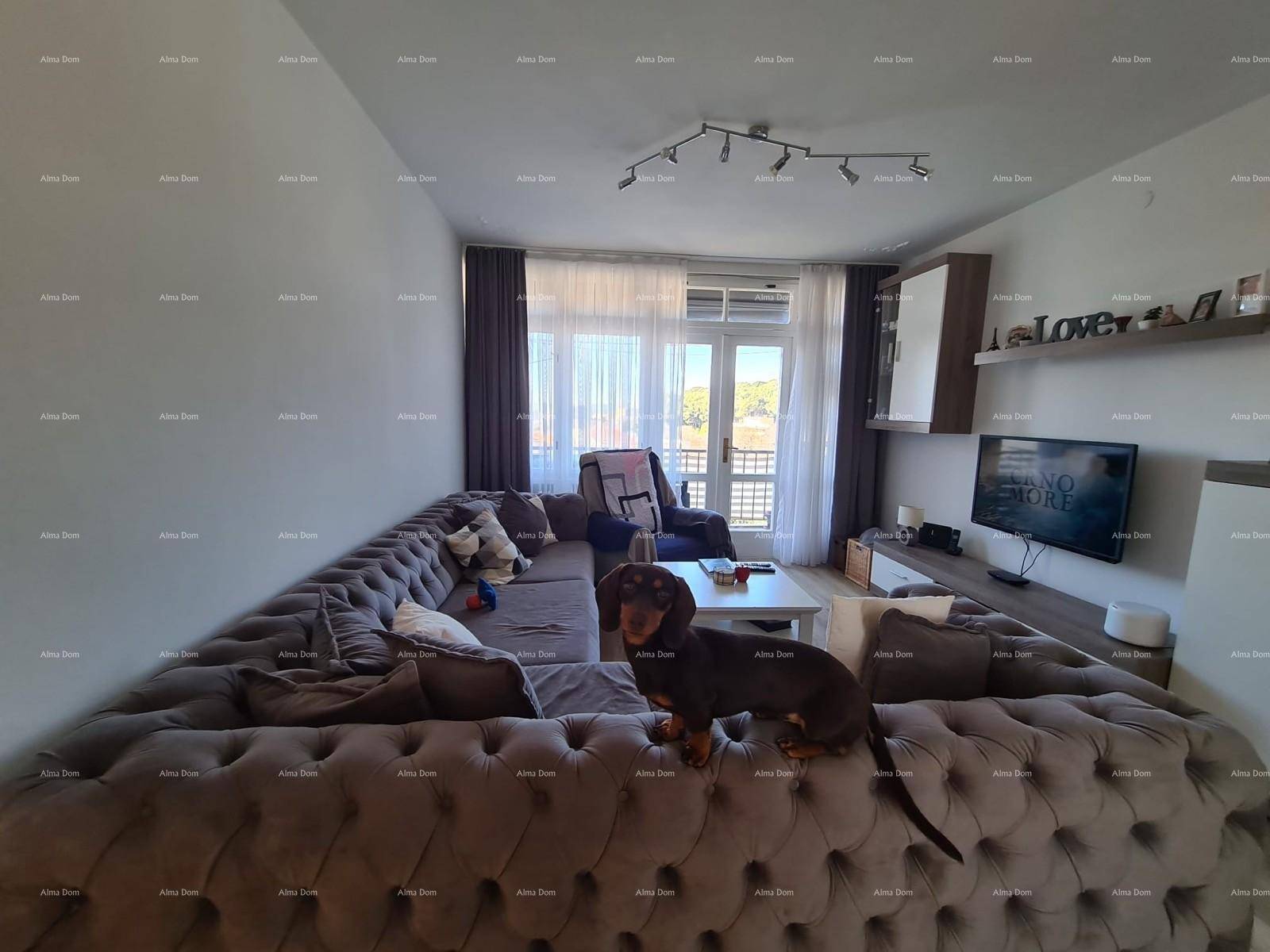 Gemütliches Wohnzimmer mit großem Ecksofa und Blick auf den Balkon.
