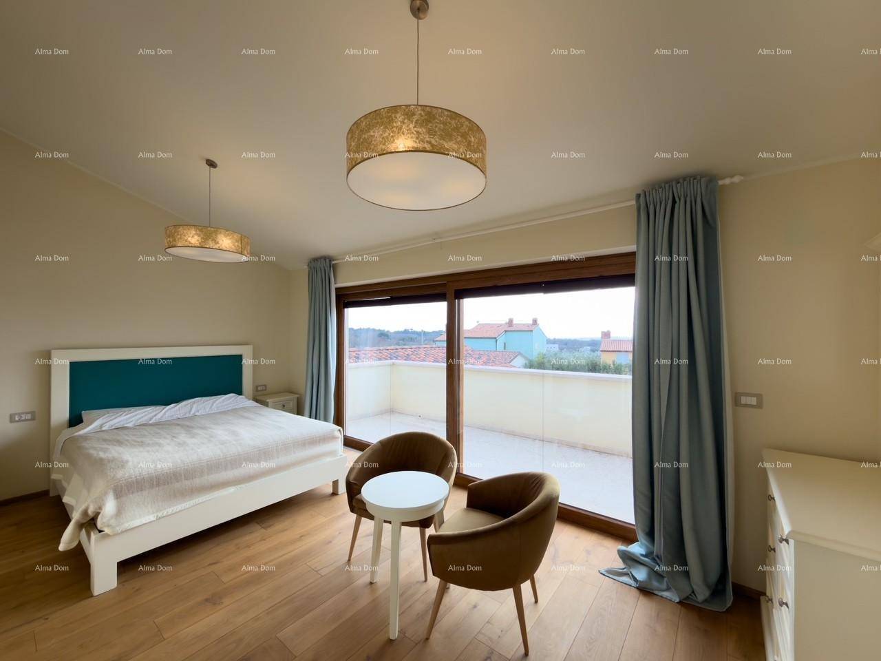 Schlafzimmer mit Doppelbett, Sitzgelegenheit und weitem Ausblick durch die großen Terrassentüren.