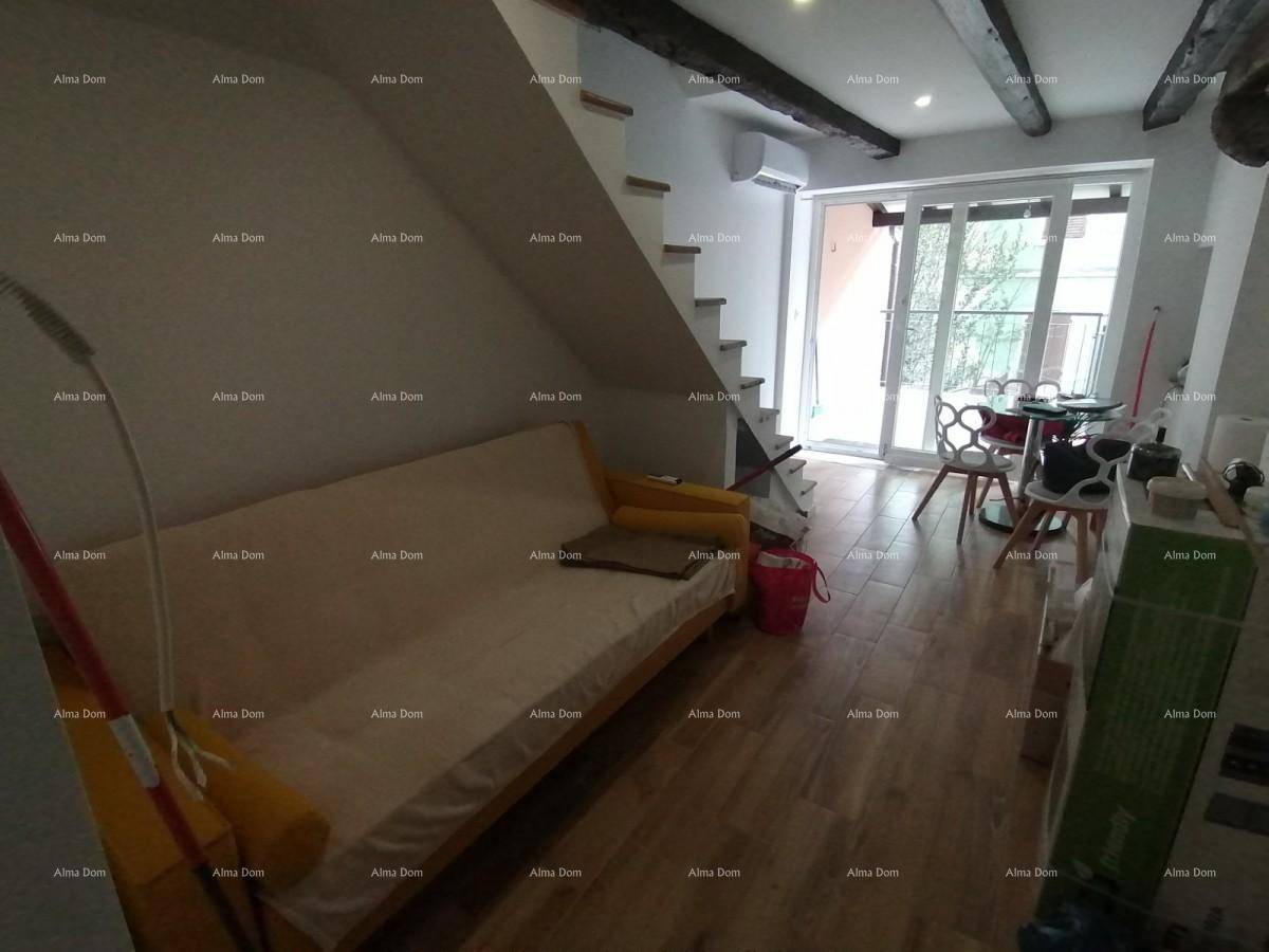 Offener Wohnbereich mit Sofa, Esstisch und sichtbaren Holzdeckenbalken.