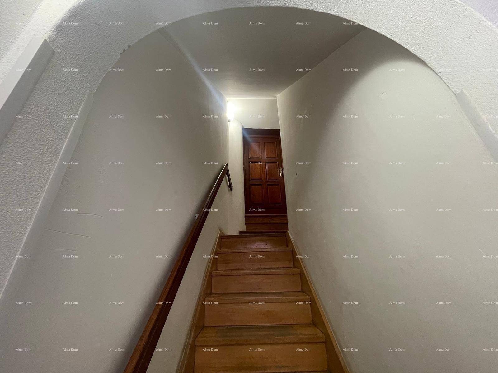 Treppenhaus mit Holzstufen und Geländer, das zu den oberen Etagen führt.