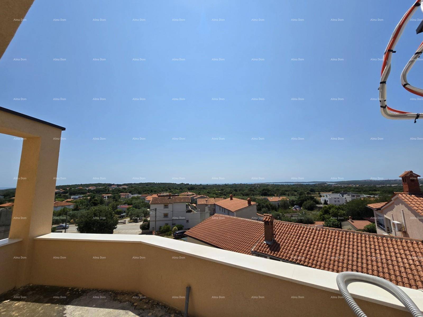 Blick von einer im Bau befindlichen Terrasse über Dächer, grüne Landschaft und das Meer in der Ferne.