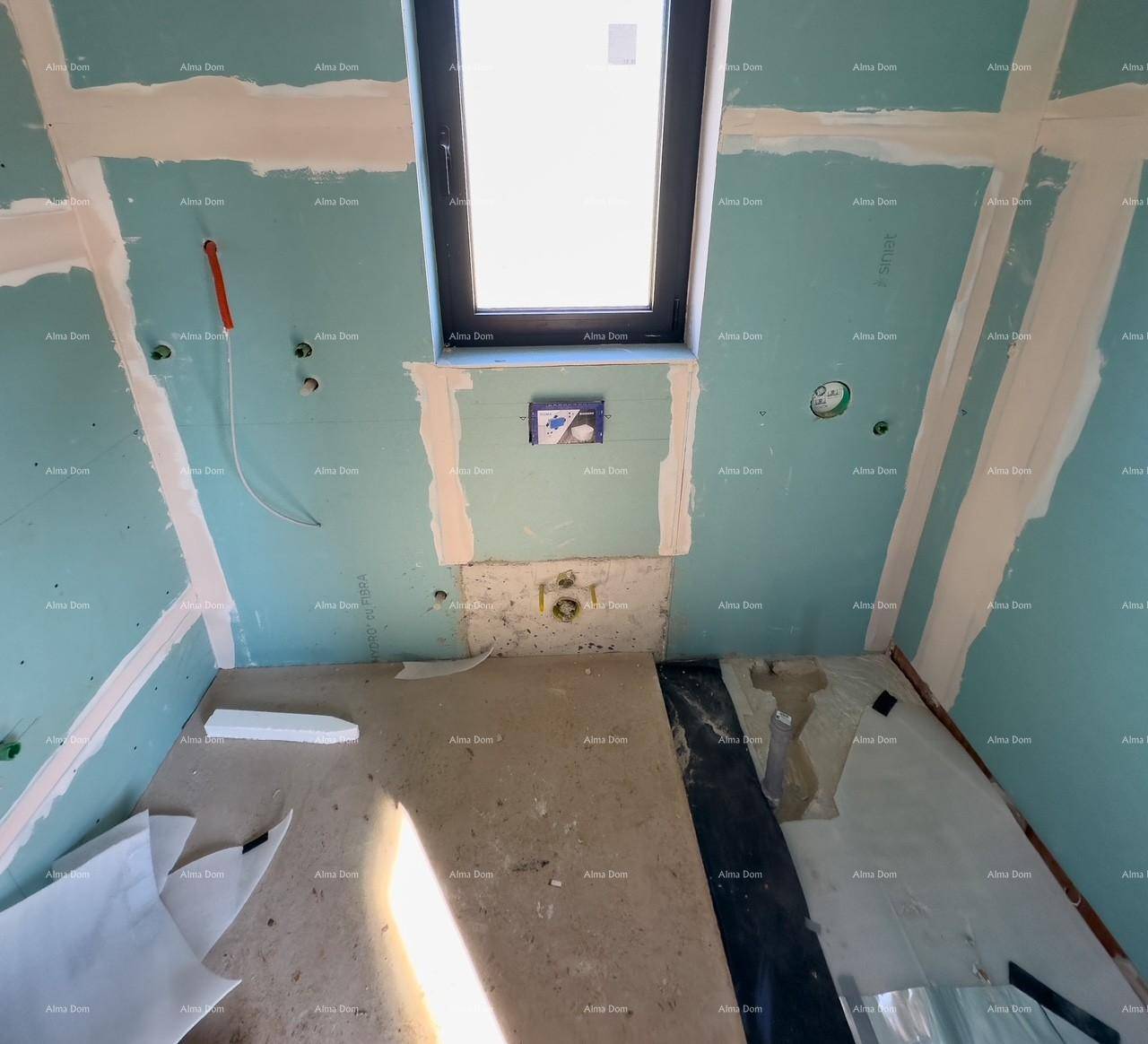 Rohbau-Badezimmer mit blauen Trockenbauwänden, Fenster und sichtbaren Bodeninstallationen für die Dusche oder Badewanne.