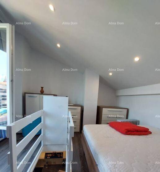 Schlafzimmer im Dachgeschoss mit Einzelbett, Stauraum und schräger Decke, neben einer Treppe.
