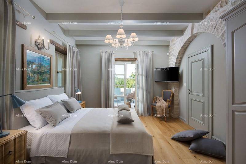 Helles Schlafzimmer mit Holzboden, Balkonzugang und traditionellen Deckenbalken.
