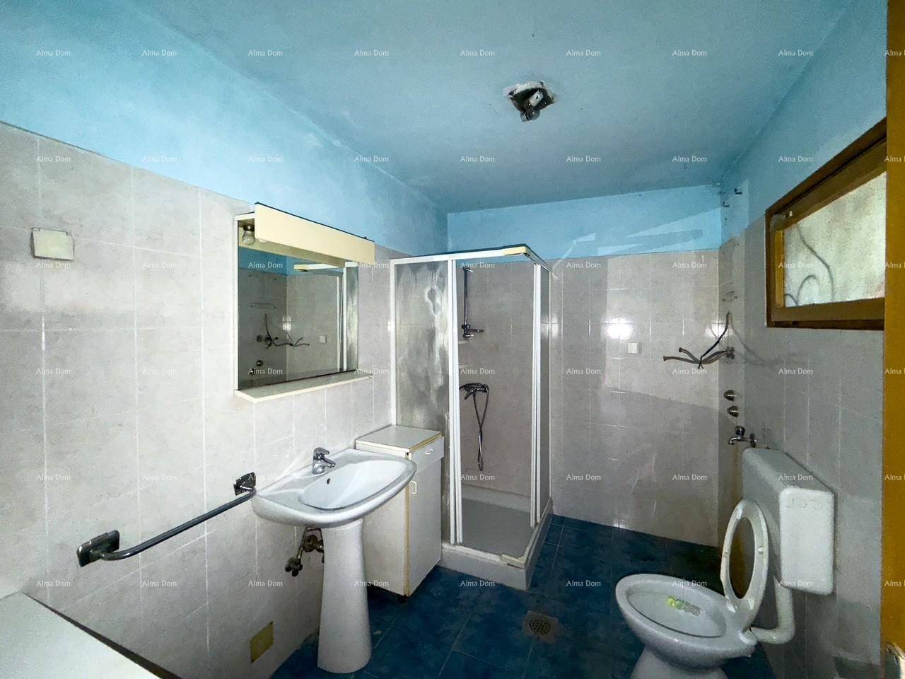 Badezimmer mit Dusche, WC, Waschbecken und hellblauen Fliesen, ausgestattet mit Haltegriffen.