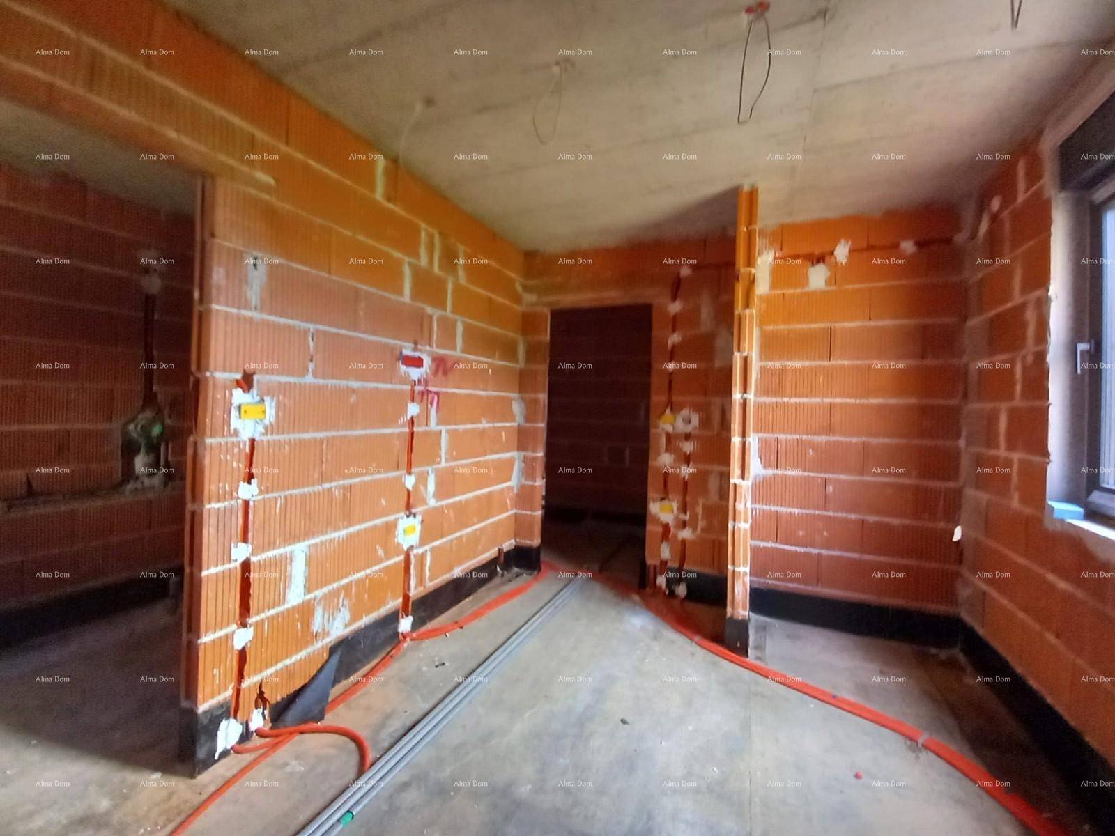 Innenraum im Rohbau mit Fenster, Ziegelwänden und zahlreichen Elektroinstallationen.