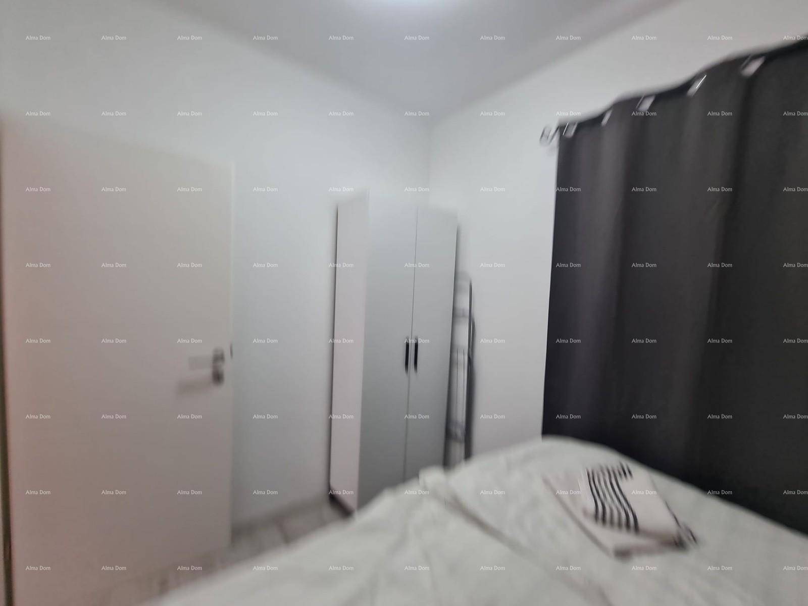 Schlafzimmer mit Doppelbett und weißem Kleiderschrank, dunkle Vorhänge am Fenster.