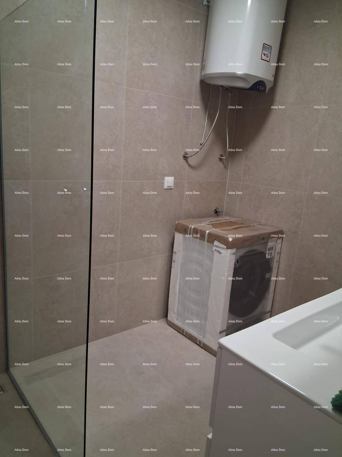 Badezimmer mit Duschkabine, Waschbecken und Warmwasserboiler.