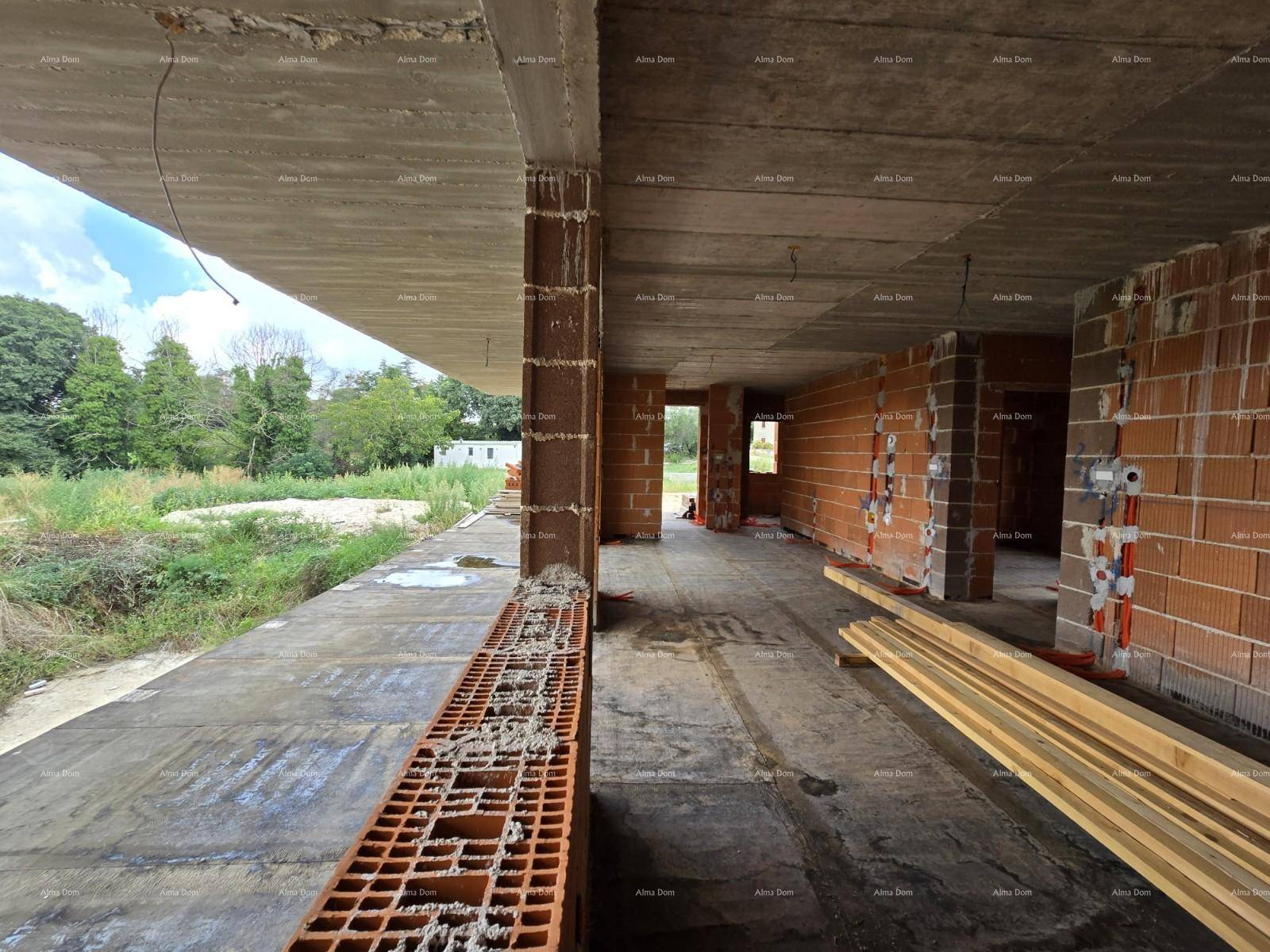 Großer offener Raum im Rohbau mit Ziegelwänden, Betonplatte und Blick auf die Umgebung.