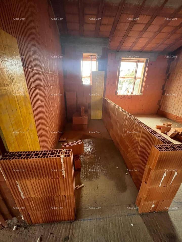 Innenraum im Rohbau mit Ziegelwänden, Betonboden und zwei Fenstern, bereit für den Ausbau.