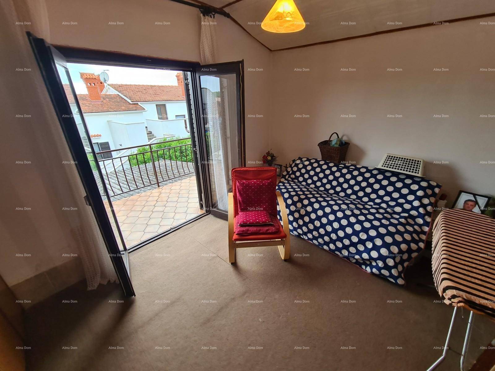 Raum mit Zugang zu einem gefliesten Balkon und einem Sofa mit Punktmuster, hell und funktional.