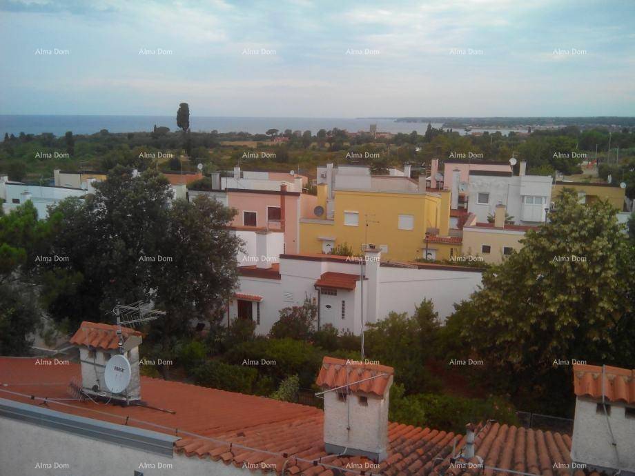 Panoramablick über die Dächer der Stadt mit dem Meer in der Ferne und viel Grün.