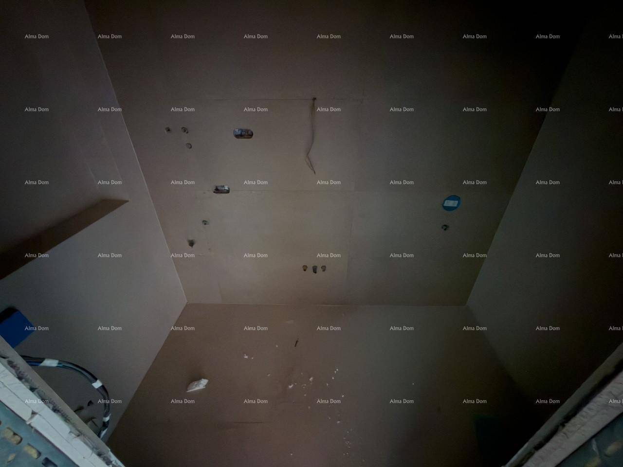 Unfertige Decke eines Innenraums mit sichtbaren Installationen und Verkabelungen.