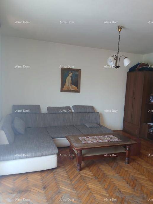 Gemütliches Wohnzimmer mit großem Ecksofa, Holztisch und Fischgrätparkettboden.