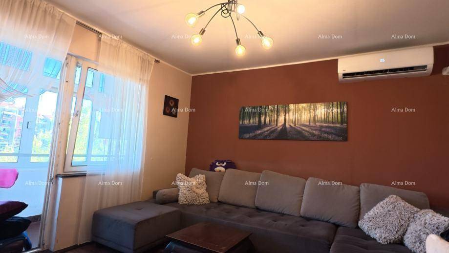 Gemütliches Wohnzimmer mit großem Ecksofa, Klimaanlage und Zugang zum Balkon.