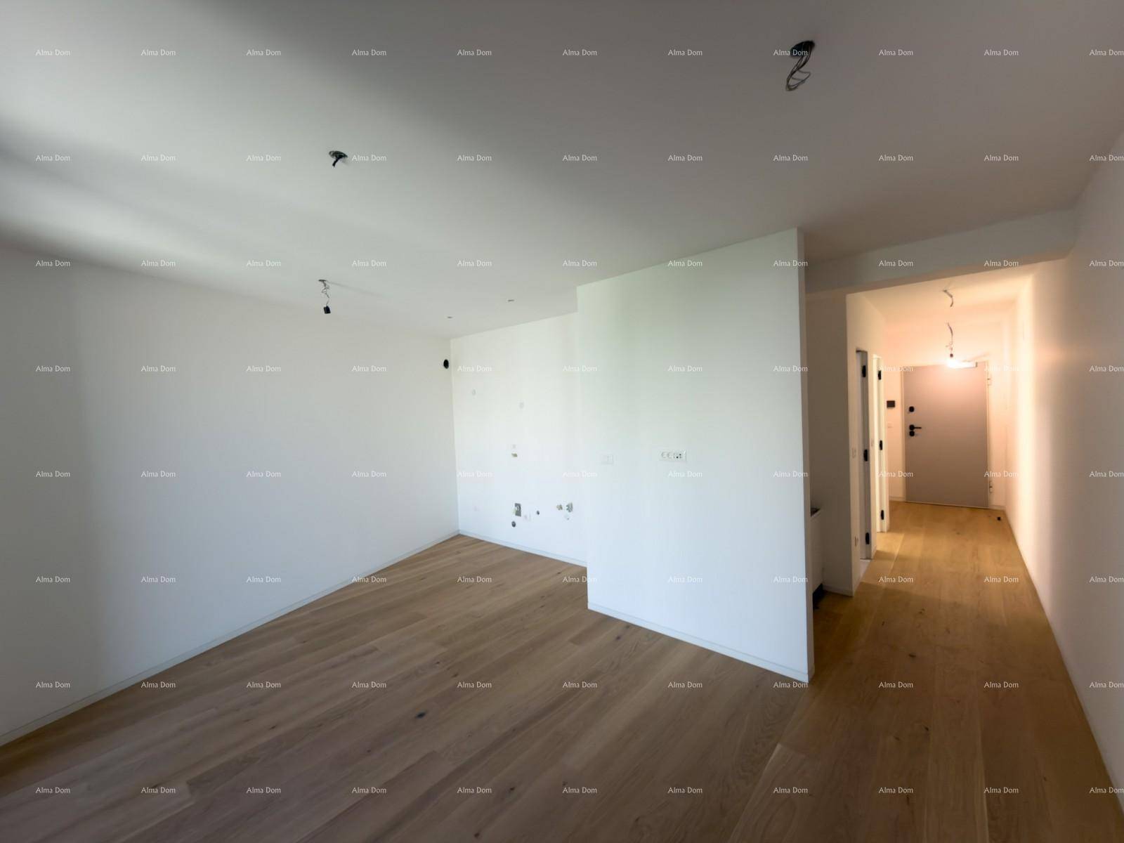 Geräumiger Wohnbereich mit Holzboden und vorbereiteten Anschlüssen für eine Küche.