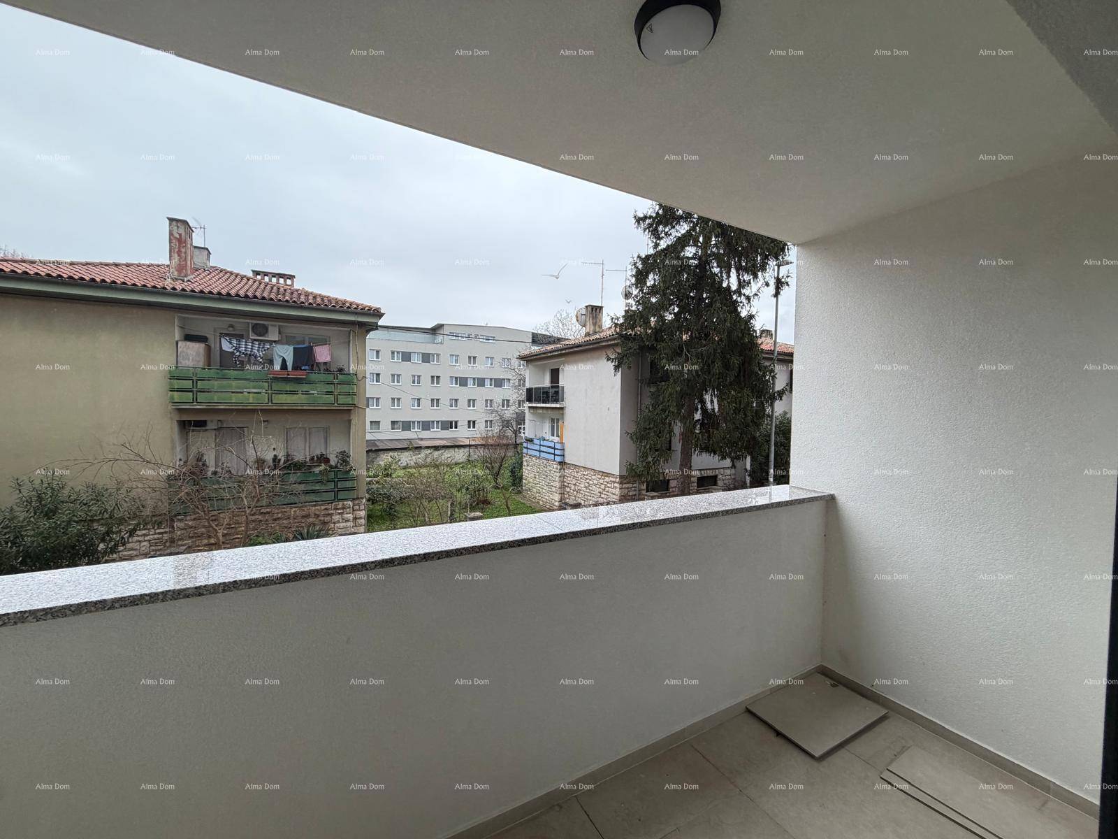 Unmöblierter Balkon mit Blick auf umliegende Gebäude und grüne Bäume.