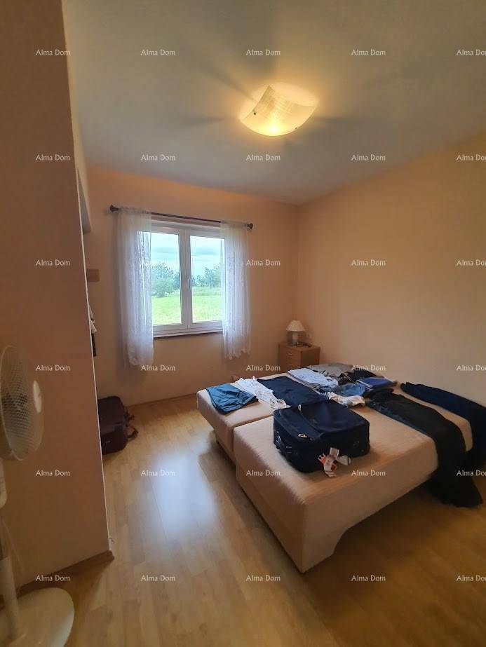 Schlafzimmer mit Doppelbett, Holzfußboden und Fenster mit Blick ins Grüne.