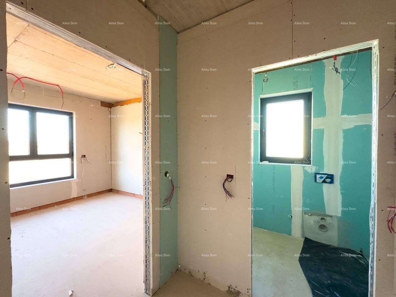 Flur im Rohbau mit zwei Türöffnungen, eine davon führt zu einem Badezimmer mit blauen Wänden.