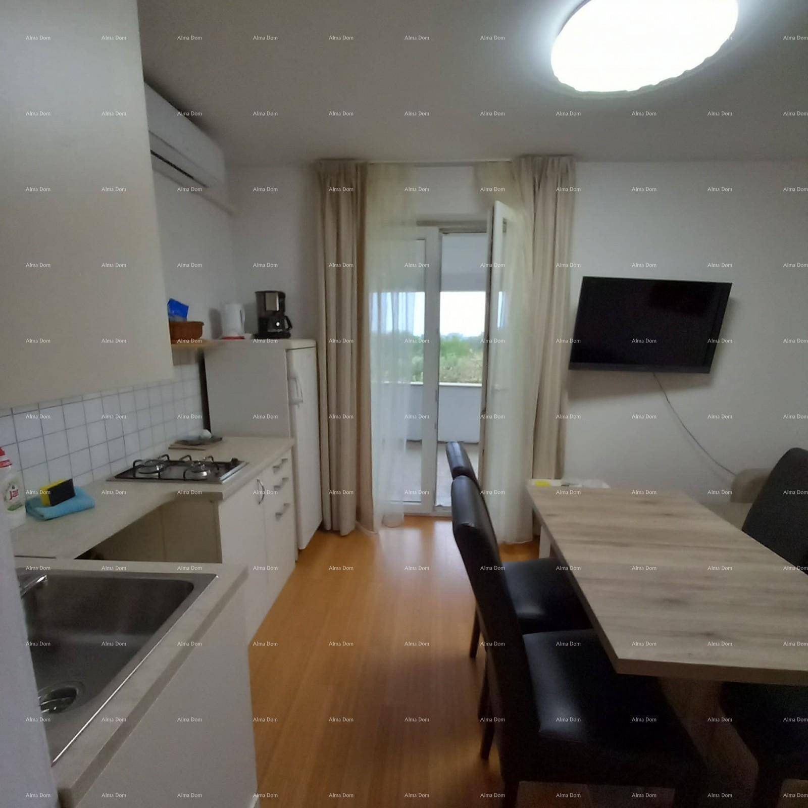 Helle Küchenzeile mit Essbereich und direktem Zugang zu einem Balkon, ausgestattet mit Klimaanlage.