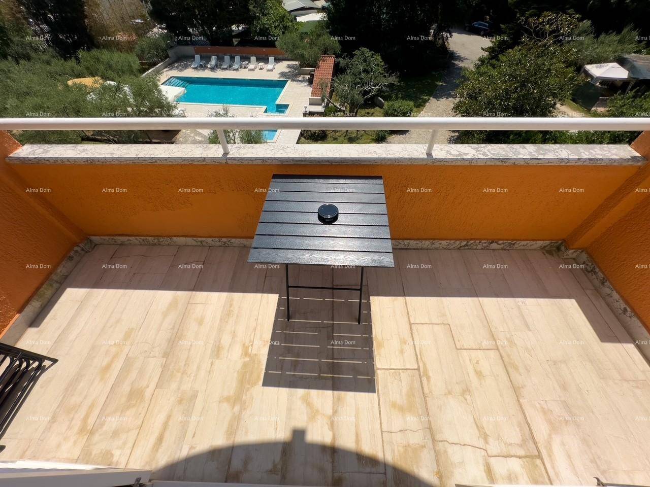 Balkon mit kleinem Tisch und Blick auf den Poolbereich und die umliegende Landschaft.