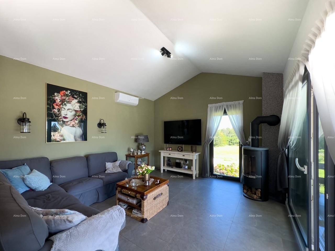 Helles Wohnzimmer mit Kaminofen, großem Sofa und Blick ins Grüne.
