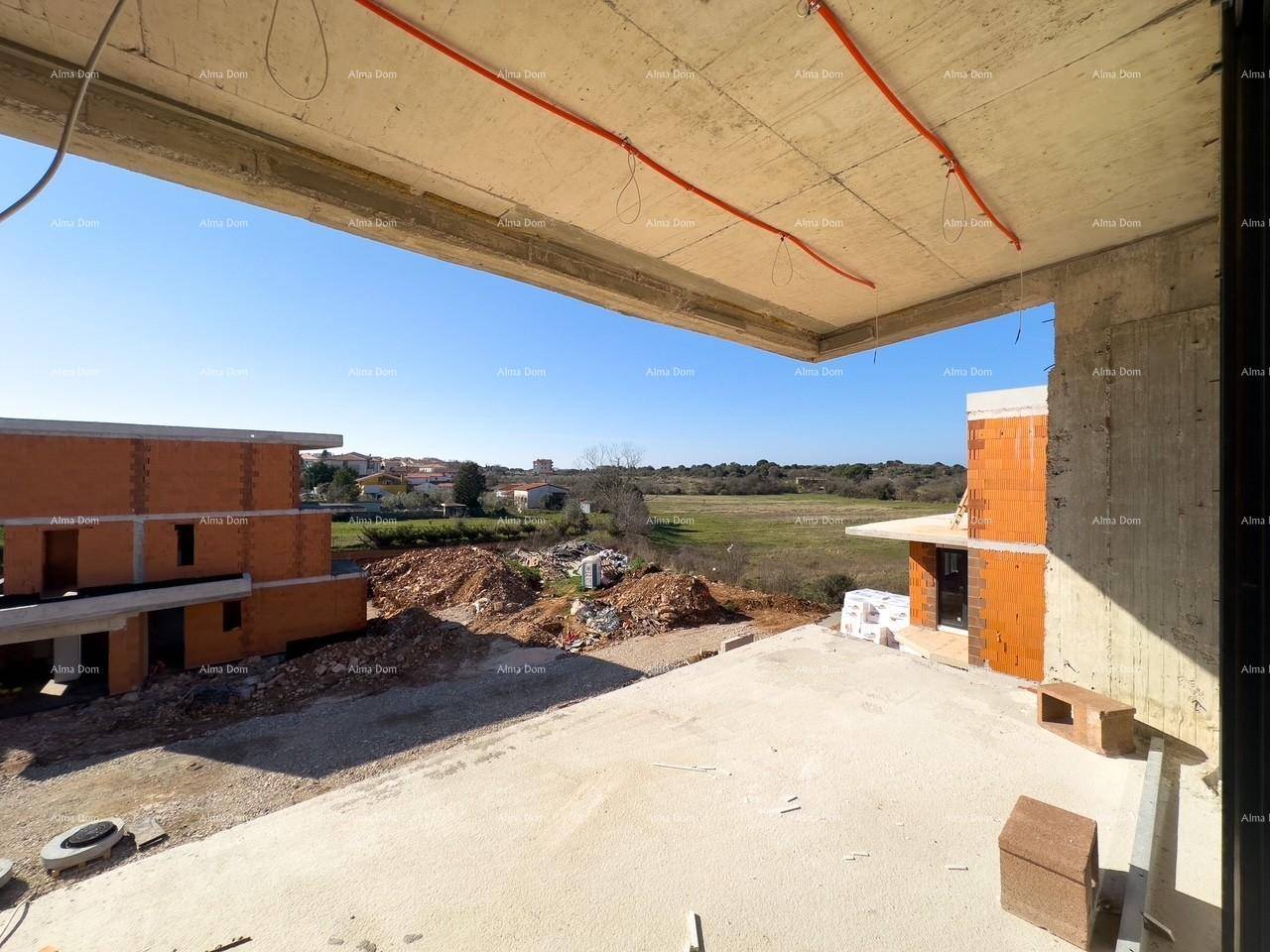 Blick von einer im Bau befindlichen Terrasse auf weitere Gebäude und die umliegende Landschaft.