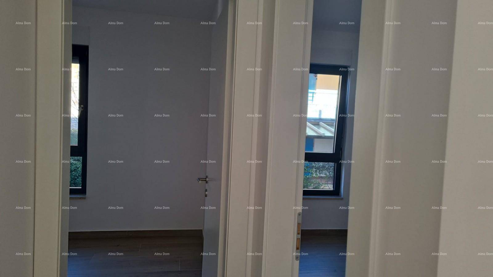 Blick durch eine Tür in einen hellen Raum mit Fenster und Holzboden.