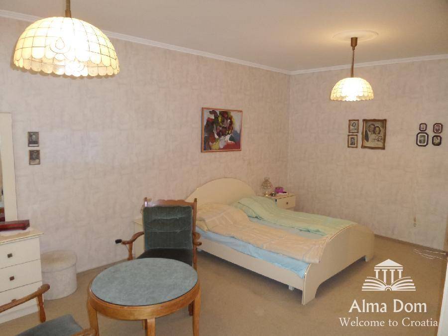 Helles Schlafzimmer mit Einzelbett, Teppichboden und traditionellen Hängelampen, schlicht und funktional.