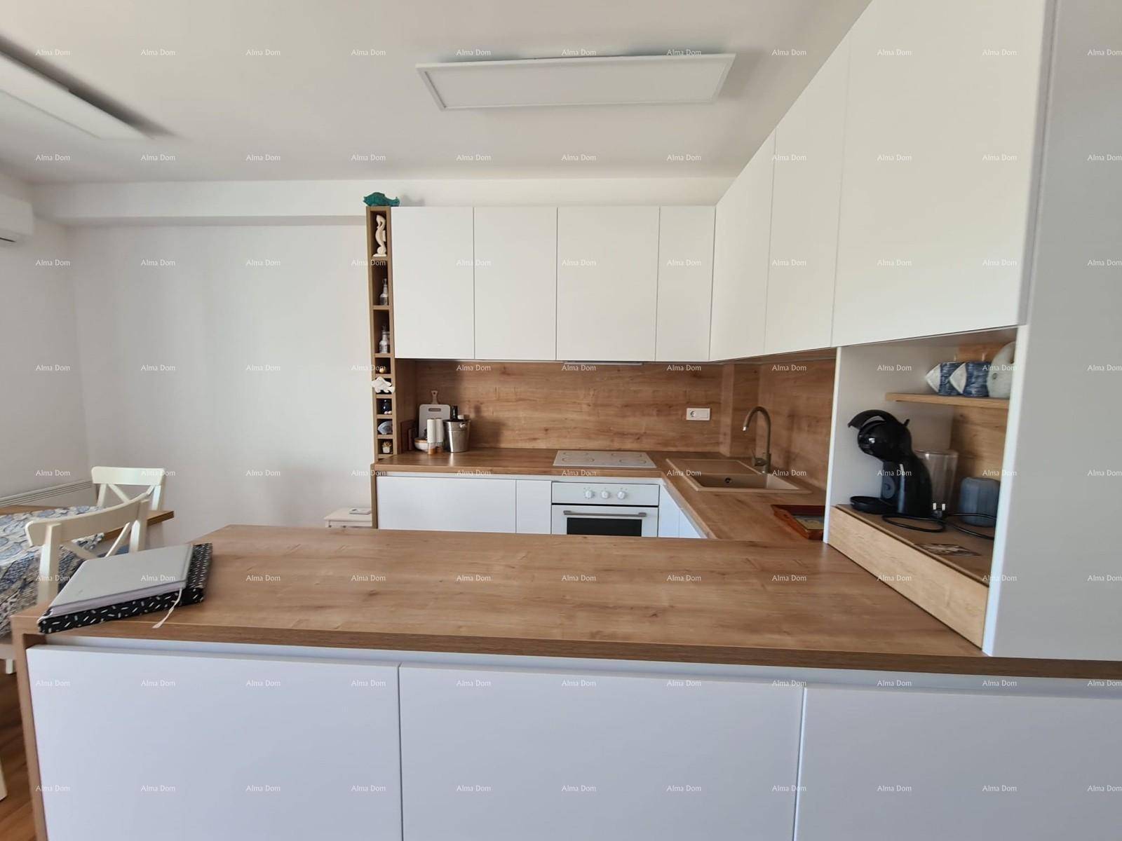 Gut ausgestattete Küche mit weißen Schränken, Holz-Arbeitsplatten und modernen Küchengeräten.