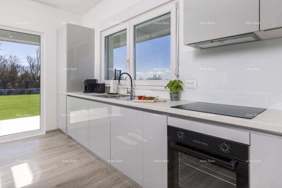 Helle, moderne Küche mit glänzenden grauen Fronten, Induktionskochfeld und Fensterblick.
