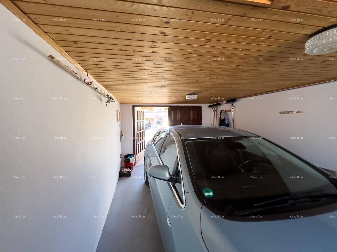 Geräumige Garage mit Holzbalkendecke und einem geparkten Auto.