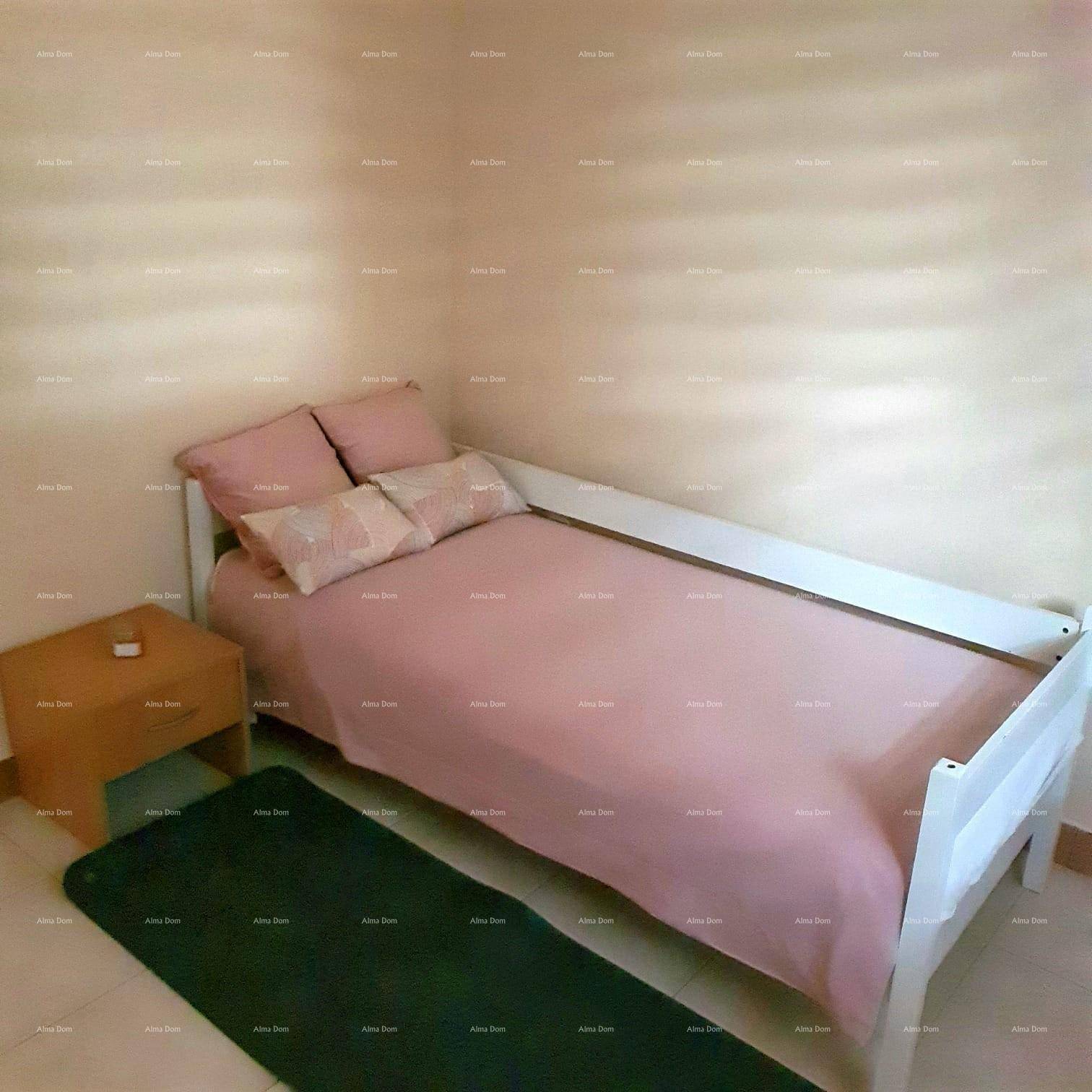 Kinderzimmer oder Gästezimmer mit Einzelbett, Nachttisch und rosa Bettwäsche.