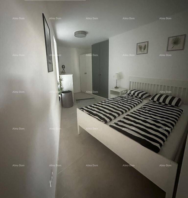 Helles Schlafzimmer mit zwei Einzelbetten, modernen Möbeln und gestreiften Bettwaren.
